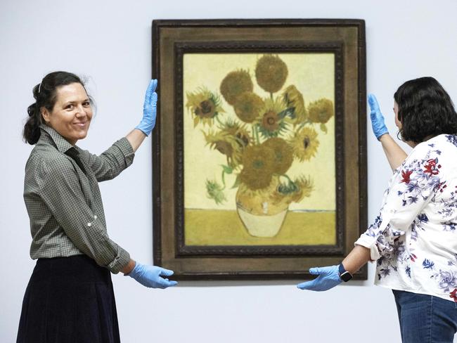 The installation team at the National Gallery, London with Van Gogh’s masterpiece, Sunflowers. Picture: NCA NewsWire/Gary Ramage