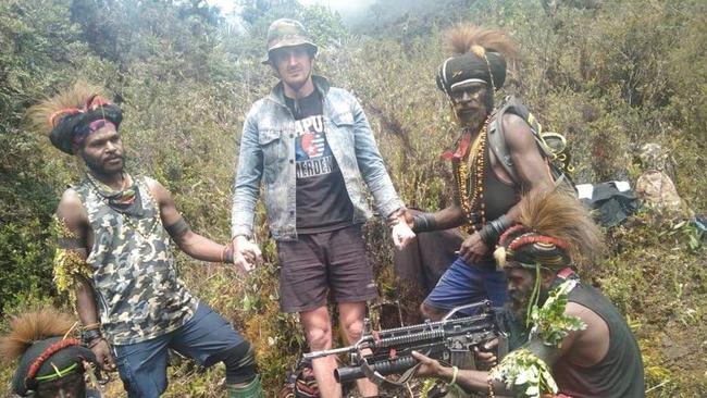 Kidnapped New Zealand pilot Philip Mark Mehrtens with his Papuan rebel captors. Picture: Twitter