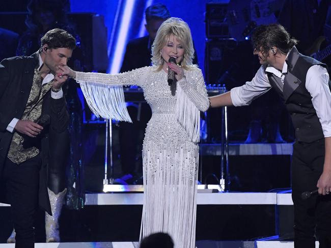 Dolly Parton performs with Joel Smallbone, left, and Luke Smallbone, right, of For King &amp; Country. Picture: AP