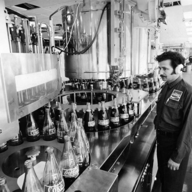 View of a worker looking over bottles filling with Coca-Cola on the $1 million dollar bottling line, which was installed in 1973 at the Thebarton factory of C-C Bottlers, Adelaide, South Australia. August 21, 1975. Picture: Supplied