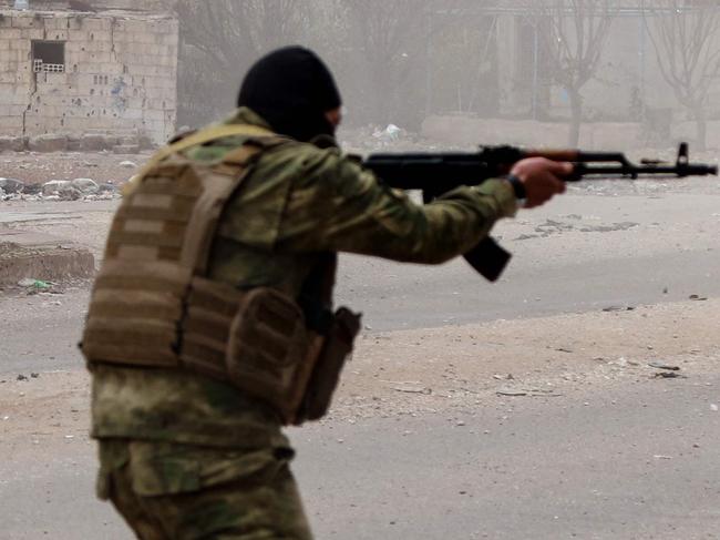 A member of Syria's new authorities security forces fires his weapon in Sanamayn, in the southern province of Daraa, during a reported large scale military campaign on March 5, 2025. Syria has seen clashes and shootings in a number of areas, often blamed on Assad supporters, with the new authorities announcing campaigns targeting "regime remnants" and making arrests. (Photo by Bakr ALKASEM / AFP)