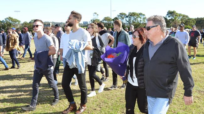 The Warringah Rats community walks to the field for the tribute.