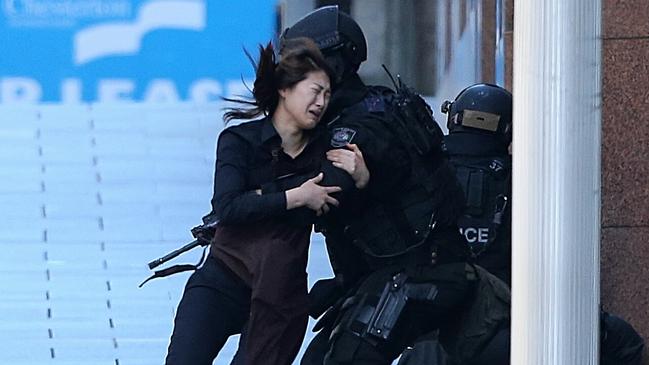 A hostage reaches safety in the 2014 Lindt cafe siege in Sydney’s Martin Place. Picture: Adam Taylor