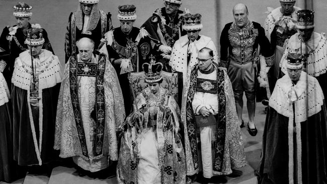 Queen Elizabeth II sits on a throne during her coronation in Westminster Abbey.