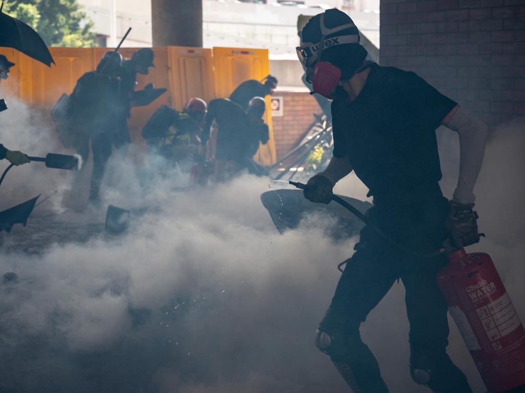 University students and protesters react after police fire tear gas to the campus of the Hong Kong Polytechnic University during a protest. Picture: Philip Fong/AFP