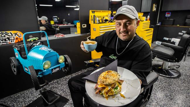 Lowrider Cafe owner Matthew Hill with a 'Lowrider breaky bagel' at his Morphett Vale cafe and barber shop in May. Picture: Tom Huntley