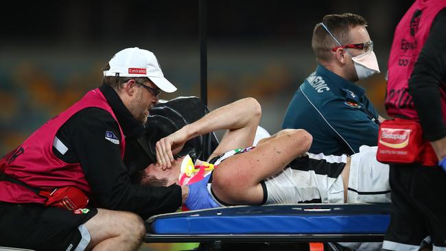 BRISBANE, AUSTRALIA – AUGUST 15: Brody Mihocek of the Magpies leaves the ground with an injury during the round 12 AFL match between the Melbourne Demons and the Collingwood Magpies at The Gabba on August 15, 2020 in Brisbane, Australia. (Photo by Jono Searle/AFL Photos/via Getty Images)