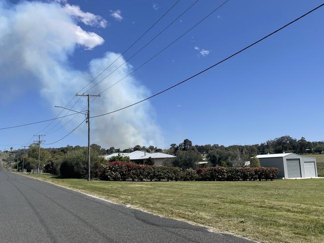 Plumes of smoke from a fast moving grass fire on Ford Rd can be seen from Warner St. Photo: Michael Hudson