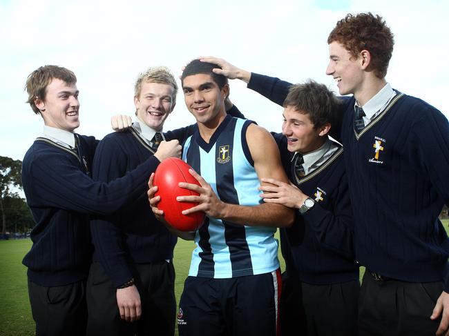 Recently retired Crow Curtly Hampton gets pats on the head and back from schoolmates in 2010 after being recruited by Greater Western Sydney. Picture: Simon Cross.