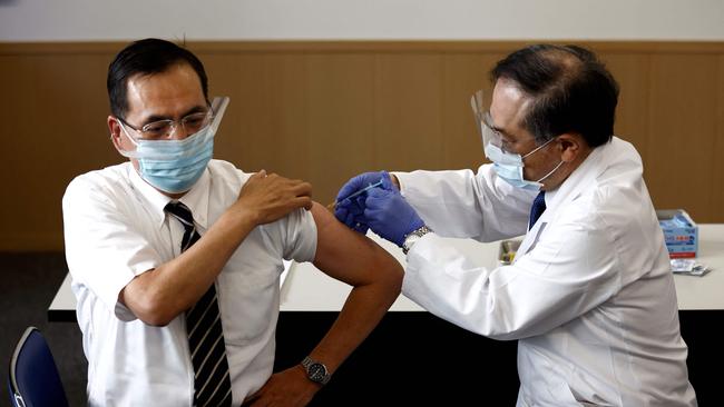 Director of the Tokyo Medical Center Kazuhiro Araki, left, receives a dose of the COVID-19 vaccine as the country launches its inoculation campaign in Tokyo today. Picture: AFP