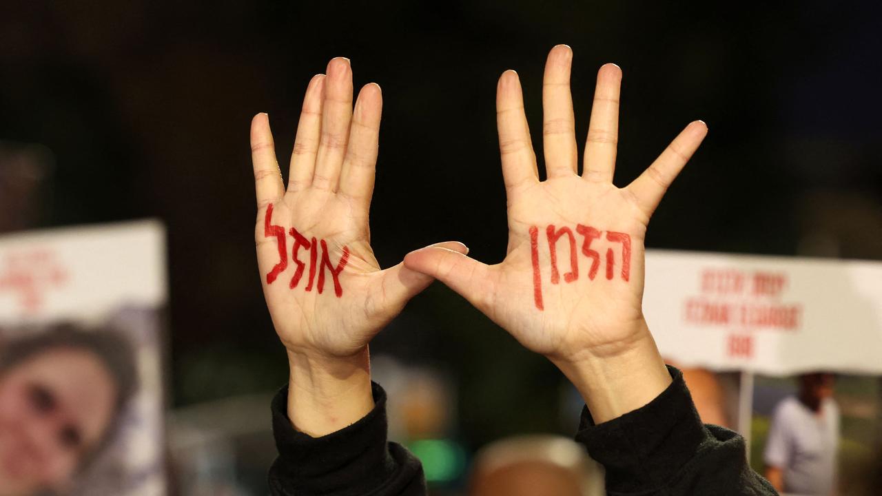 A protester flashes a message in Hebrew reading in English "there is no time", during a rally organised by family and supporters of Israeli hostages. Picture: AFP