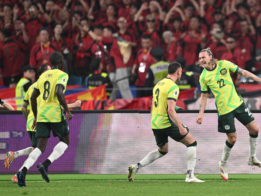 Jackson Irvine (right) celebrates with teammates after scoring for the Socceroos in Australia’s 2-0 win over China. Picture: Hector Retamal / AFP