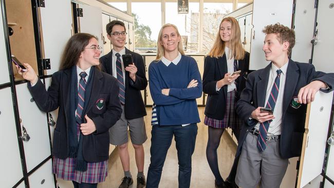 McKinnon Secondary College teacher Lauren Mauger with students Alyssa, 15, Akira, 15 Jordan, 14, and Ben, 15, have already faced the mobile phone ban. Picture: Jason Edwards