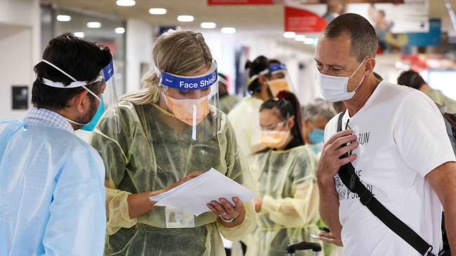 Travellers from Sydney have their permits checked in the Qantas terminal at Melbourne Airport. Picture: Ian Currie