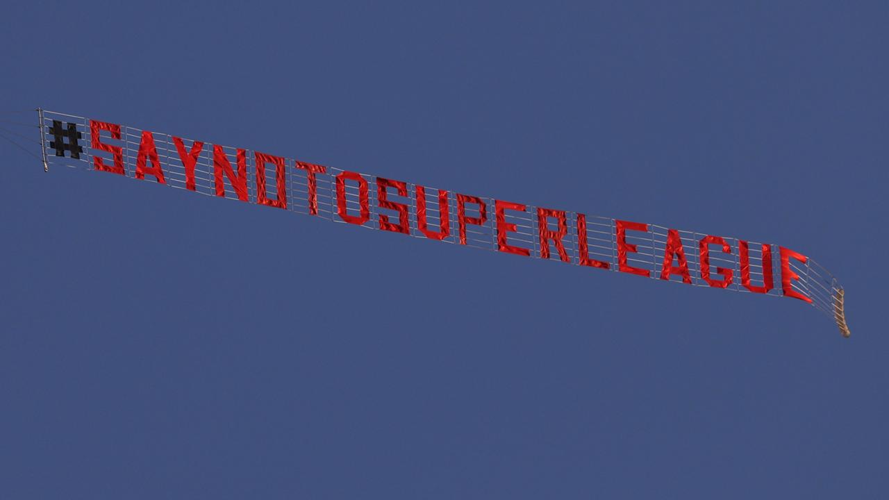 A sign is trailed by a plane with a slogan against a proposed new European Super League over the stadium during the warm up for the English Premier League football match between Leeds United and Liverpool at Elland Road. (Photo by Clive Brunskill / POOL / AFP)
