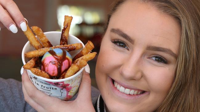 Tayla Dillon, 22, of Beenleigh tries donut fries at Dreamworld. Picture Glenn Hampson