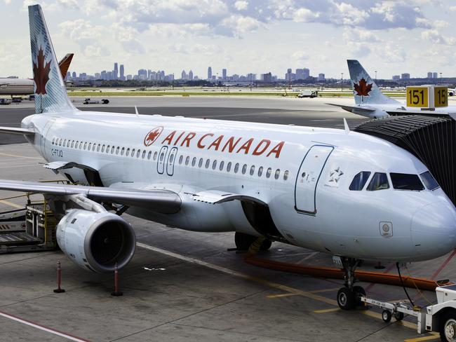 Toronto, Ontario, Canada - August 29, 2011: At Toronto Pearson International Airport, a commercial, Air Canada jet is being loaded and prepped for departure. Doors open on aircraft ready to loading baggage.