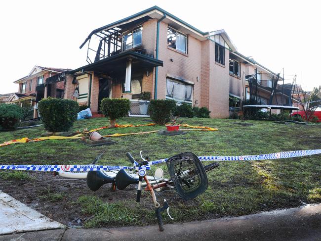 A child’s bike lies outside the burnt out home on Tuesday. Picture: John Feder