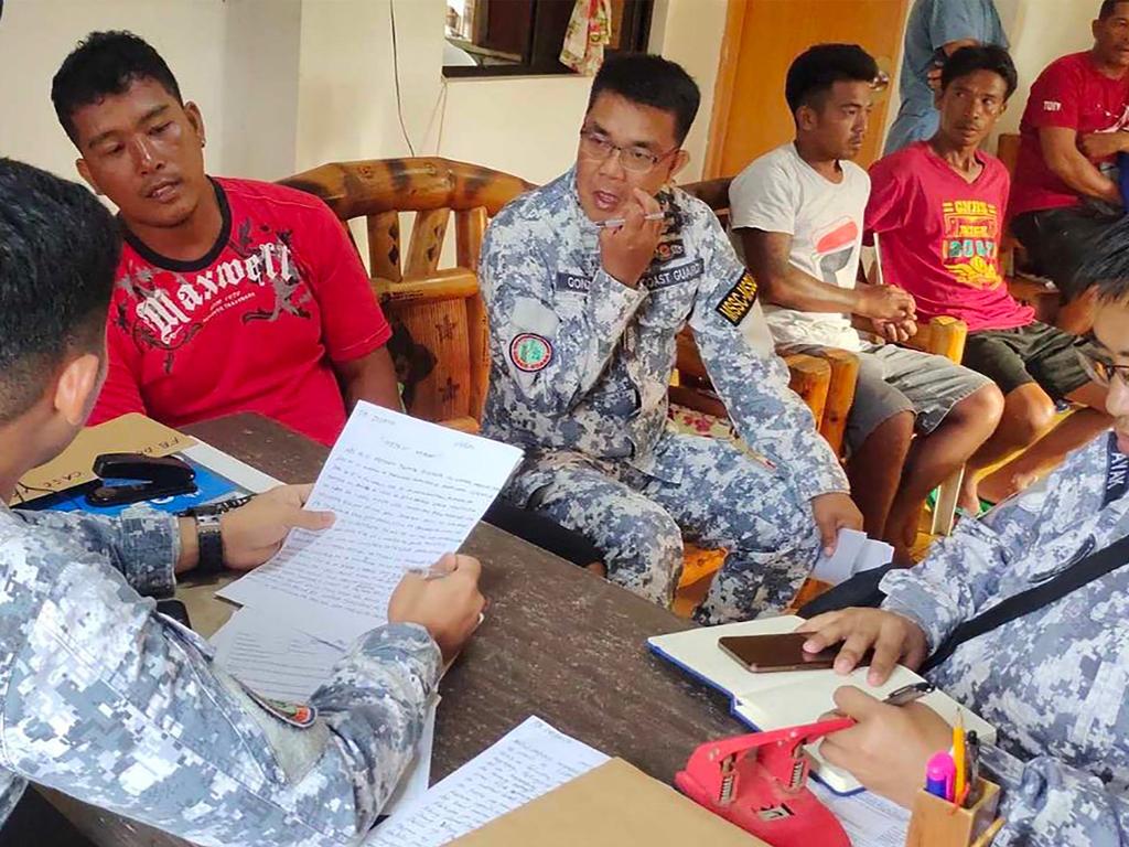 Crew members of the Filipino fishing boat reporting to personnel at the Philippine Coast Guard substation in Infanta.