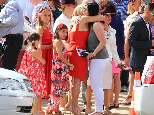 Mrs Manago with her daughters, receiving a hug. Picture: Adam Taylor