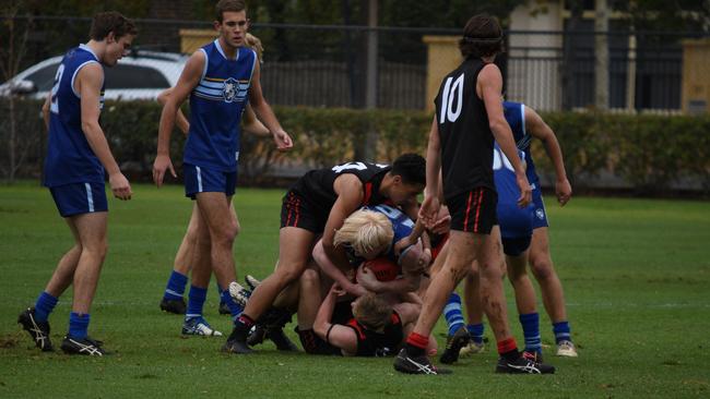 Rostrevor and Sacred Heart footballers pile on during their game on Saturday. Picture: Sam Hearn