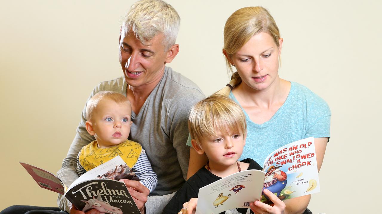 Martin Minor and partner Milena Mirow read with nine-month-old Neo and Jona, 3, at Brisbane’s State Library. Picture: Steve Pohlner