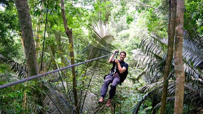 The developer and manager of The Gibbon Experience Jef Reumaux rides a zip-line.