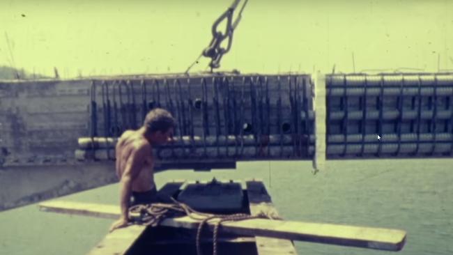 No hard hat, no shirt as tonnes of concrete are lowered into place during building of The Rip Bridge.