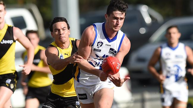 Brede Seccull gets away a handball for Sandy as Tiger Daniel Rioli closes in.