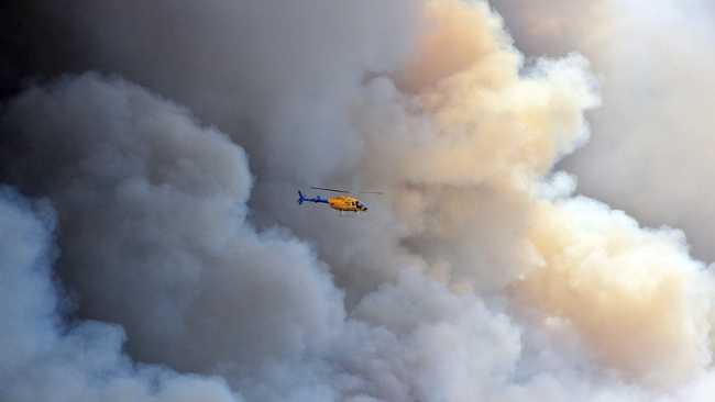 CONCERN BUT NO PANIC: A huge bushfire impacts Peregian Springs and Coolum residents as the flames threaten their homes. The fire burnt over 500 hectares and dozens of emergency crews were deployed throughout the night. An Observation helicopter.