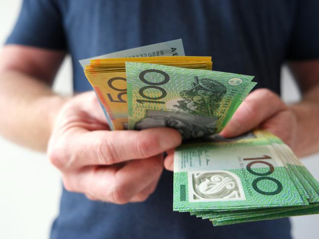 A man counting Australian dollar bills. A picture that describes buying, paying, handing out money, or showing money.