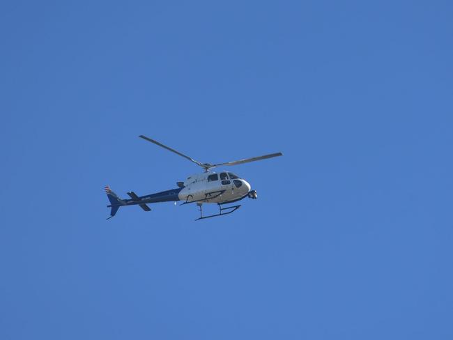 A police helicopter searches the area. Picture: Ian Wilson