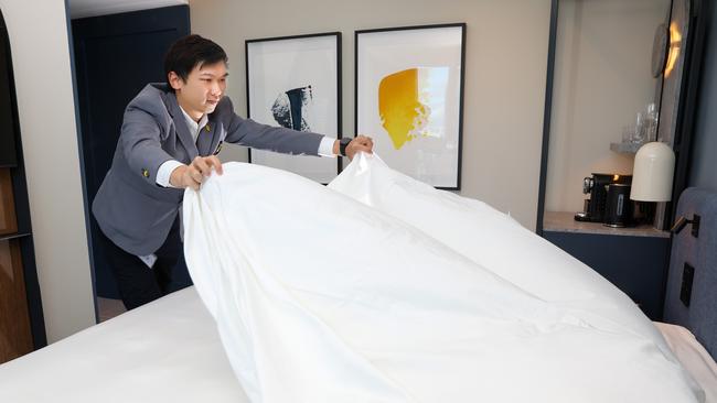 Hotel worker Charles makes a bed at the Voco Hotel. Picture: Brendan Beckett