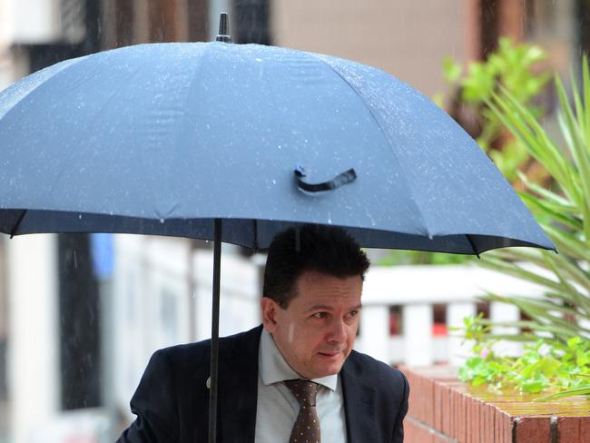 Nick Xenophon walks through the rain yesterday. Picture: Tricia Watkinson