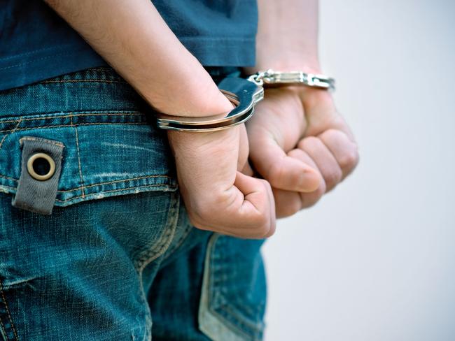 Generic Thinkstock image of youth crime - hand cuffs teenager under arrest.