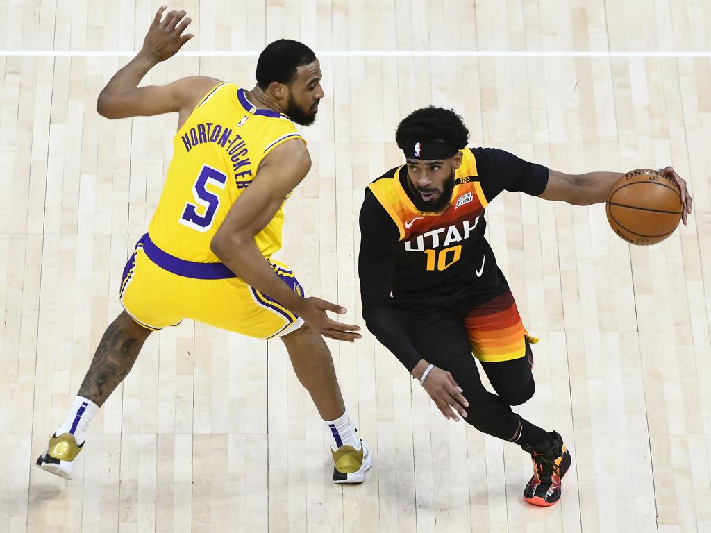 Mike Conley of the Utah Jazz drives past Talen Horton-Tucker of the Los Angeles Lakers.