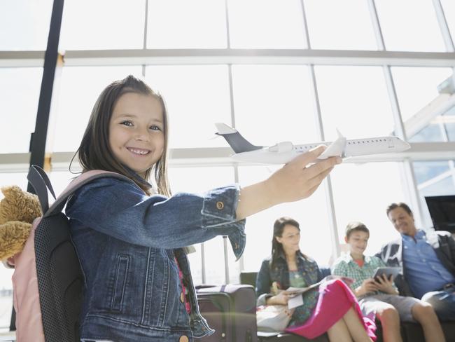 Girl playing with toy airplane in airport