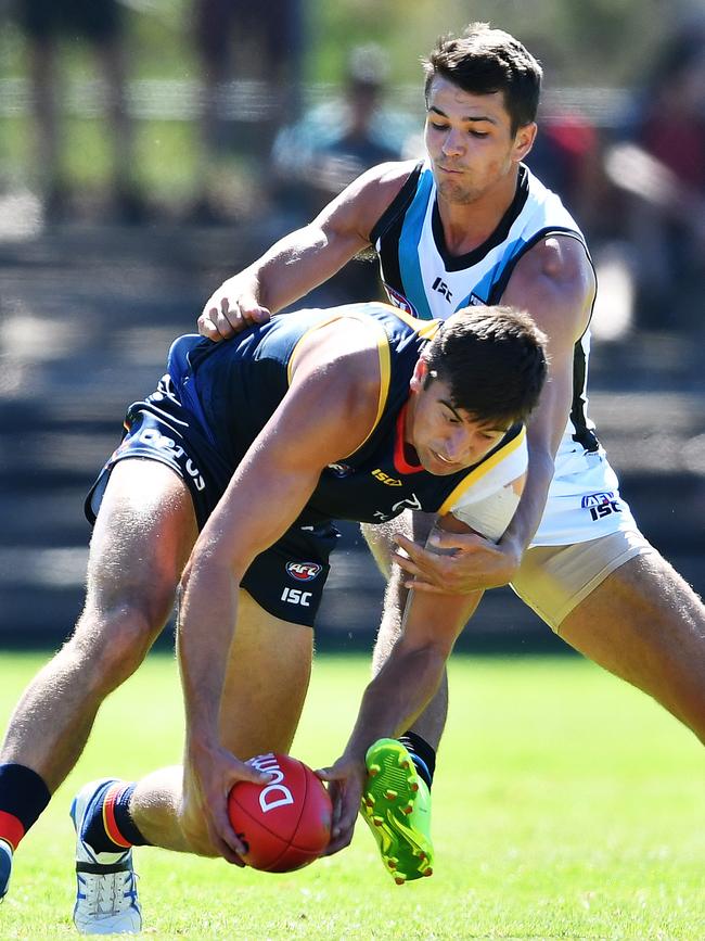 Power newcomer Ryan Burton tackles Patrick Wilson of the Crows during the Under 23 trial at Thebarton Oval on Saturday. Picture: AAP/Mark Brake