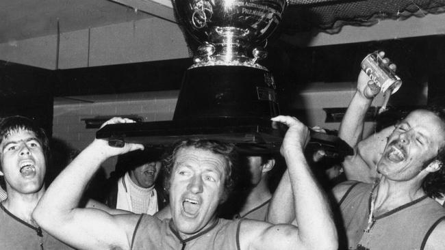 Sturt’s Robert Oatey holds the 1974 premiership cup aloft, flanked by teammates Brenton Adcock (left) and Phil "Sandy" Nelson.