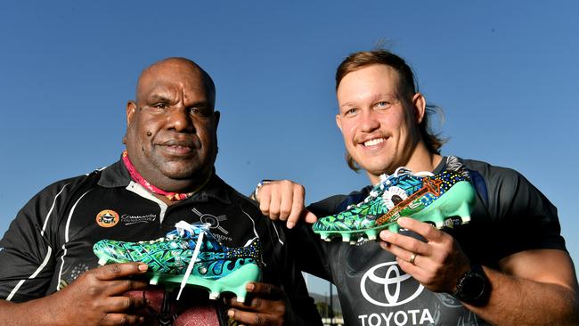 North Queensland Cowboys player Reuben Cotter with Cowboys House cultural co-ordinator Vincent Babia with the painted boots. Picture: Evan Morgan