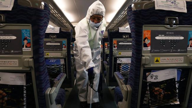 A disinfection worker wearing protective gears spray antiseptic solution in an train amid rising public concerns over the spread of China's Wuhan Coronavirus. Picture: Getty Images