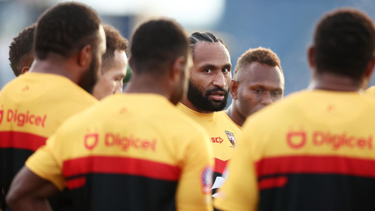 Melbourne Storm star Justin Olam talks to teammates in a huddle during a PNG team training session. Picture: Getty Images