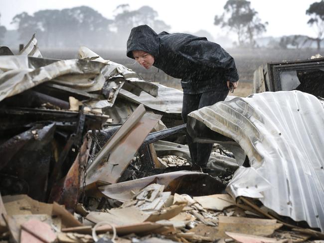 Cobden fire zone. Newly wed Rebecca Jones sifts through the remains of her newly renovated home in pouring rain at  Cobden.   Picture: David Caird