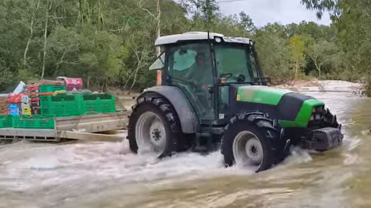 Farmer crosses flood water in tractor to deliver fruits, vegetables