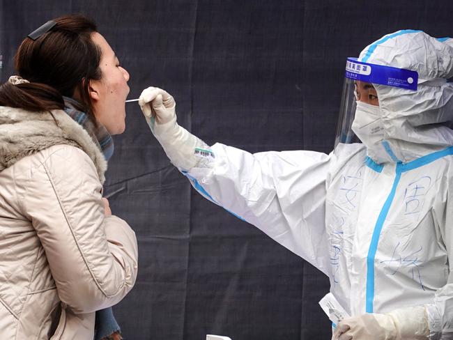 A resident undergoes a nucleic acid test for the Covid-19 coronavirus in Xi'an in China's northern Shaanxi province on December 30, 2021. (Photo by AFP) / China OUT