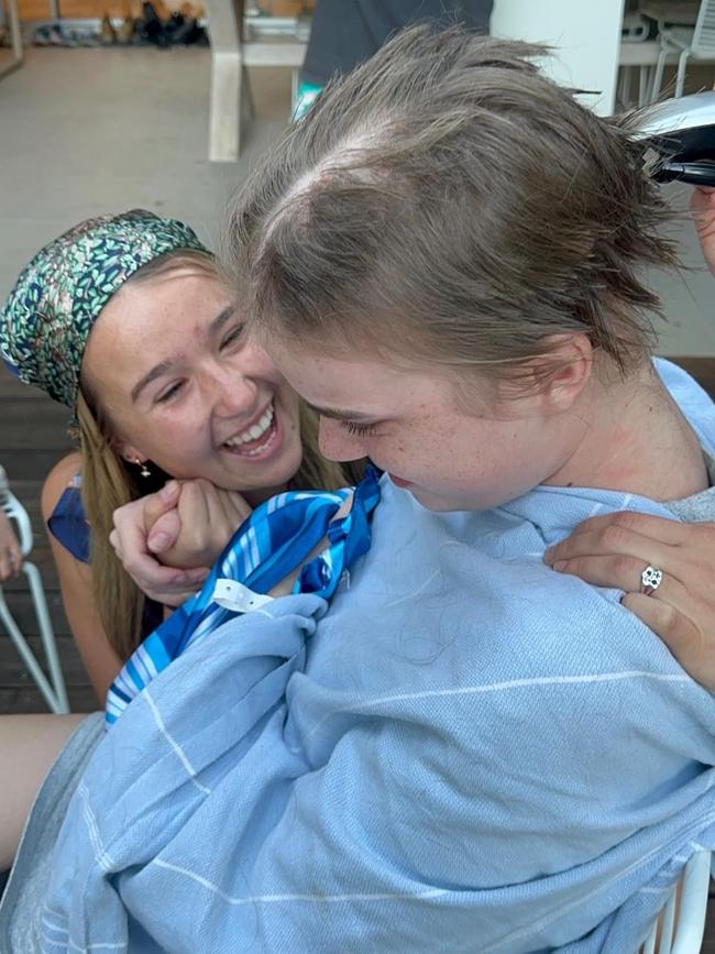 Lyla Neck has her head shaved, supported by sister Tilly. Picture: Supplied