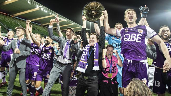 Perth Glory owner Tony Sage hoists the Premiers Plate high after his club beat Newcastle in Perth on Sunday night. Picture: AAP