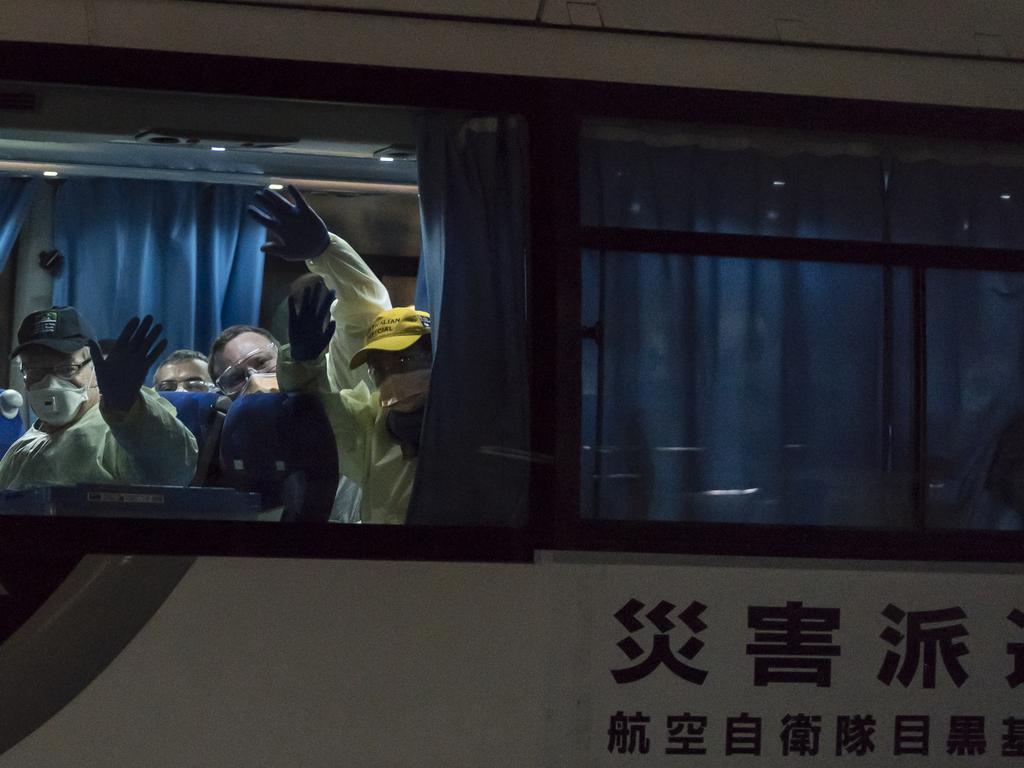 Australians wave from the bus as it takes them to the airport. Picture: Tomohiro Ohsumi/Getty Images