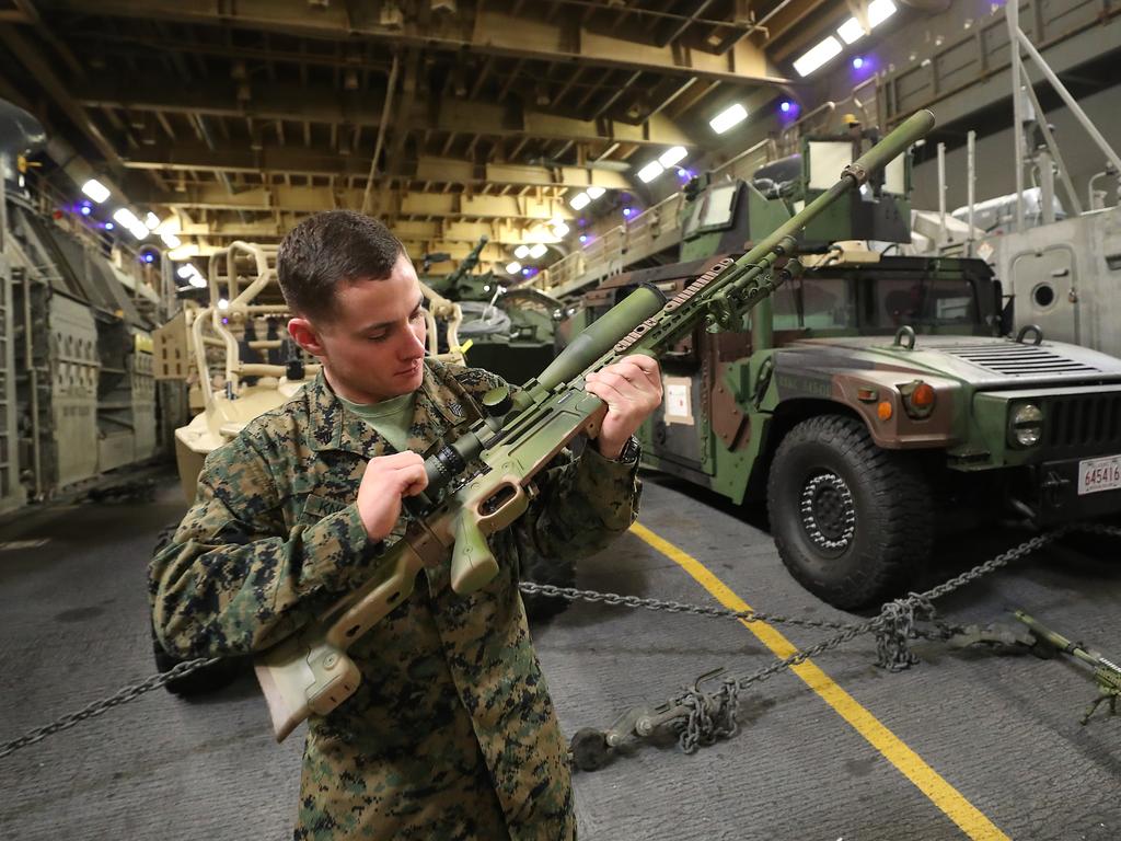 Scout sniper Sergeant Zechariah Knowlton inspecting his weapon. . Photos on board the USS Wasp. Pic Peter Wallis