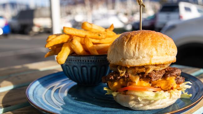 BOne of Marina Cafe’s tasty burgers, served with a side of chips, which is a veritable tower of burgery goodness. Picture: Linda Higginson